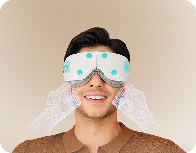 Mężczyzna uśmiecha się, używając białego masażera oczu SKG ES500, z wizualizacją masażu skroni dłońmi