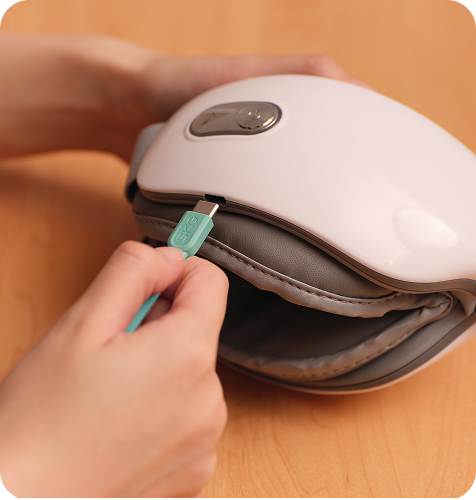 Ładowanie złożonego masażera oczu SKG ES500 za pomocą turkusowej wtyczki USB (Universal Serial Bus) typu C