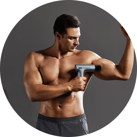 Umięśniony mężczyzna masuje napięty biceps za pomocą pistoletu do masażu SKG F1-Pro w kolorze szarym