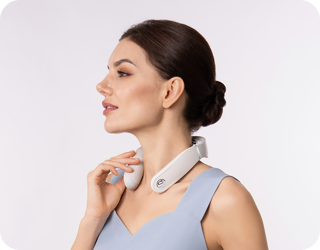 Kobieta w błękitnej sukience używa białego, bezprzewodowego masażera szyi SKG GS500-N