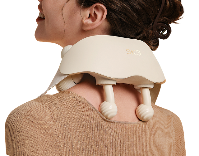 Masażer karku SKG HS500-2 w kolorze beżowym, z dwoma kulistymi głowicami, na karku uśmiechniętej kobiety