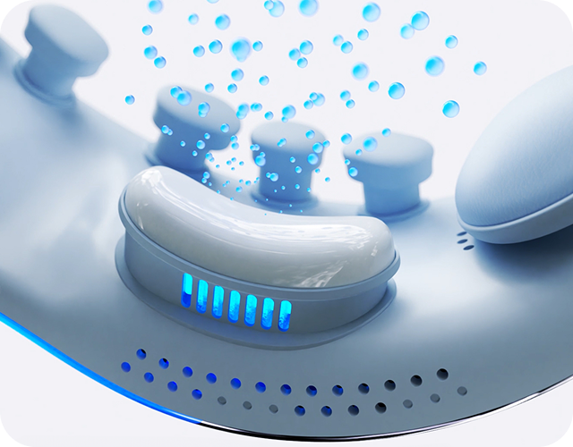 Zbliżenie na wewnętrzną część masażera oczu SKG. Widoczne są niebieskie głowice i bąbelki.