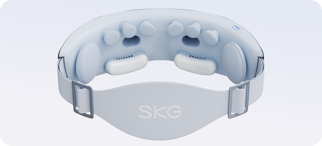 Wnętrze masażera oczu SKG KS700 z widocznymi niebieskimi i białymi podkładkami masującymi oraz regulowanym paskiem