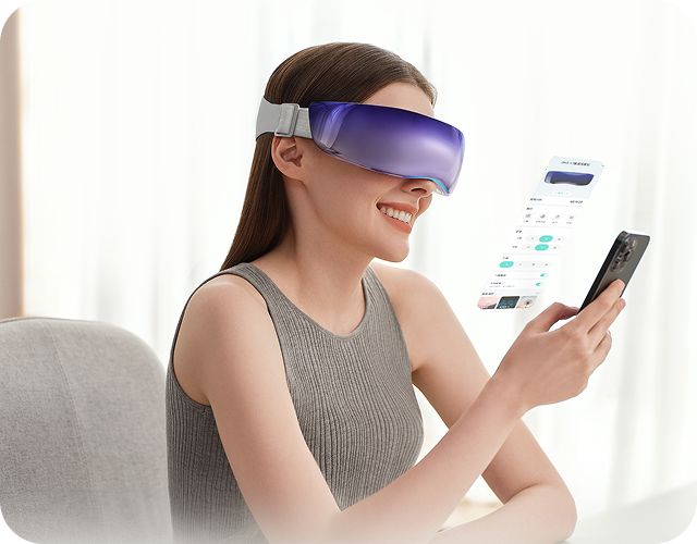 Uśmiechnięta kobieta kontroluje masażer oczu SKG KS700 poprzez aplikację na smartfonie.