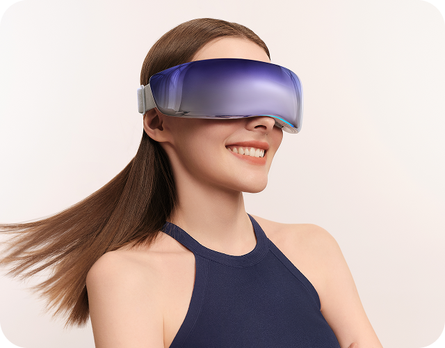 Uśmiechnięta kobieta w granatowej sukience ma na sobie masażer oczu SKG KS700