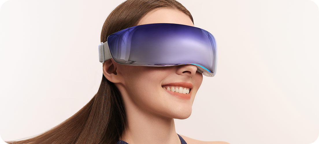 Uśmiechnięta kobieta w granatowej sukience ma na sobie masażer oczu SKG KS700