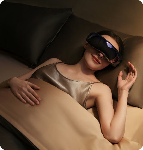 Kobieta relaksuje się w łóżku z masażerem oczu SKG KS700 na twarzy, w ciepłym, przyciemnionym świetle.