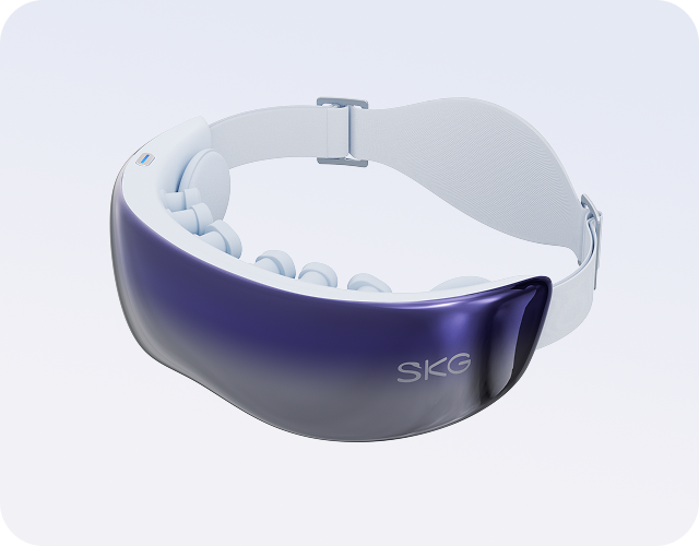 Masażer oczu SKG KS700. Widoczna fioletowo-lustrzana osłona, biały pasek i wewnętrzne podkładki masujące.