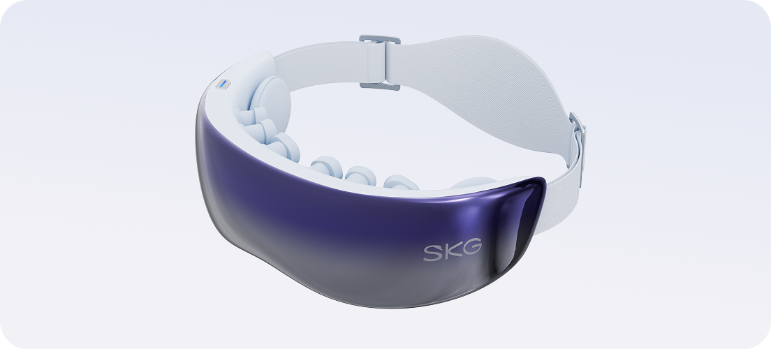 Masażer oczu SKG KS700. Widoczna fioletowo-lustrzana osłona, biały pasek i wewnętrzne podkładki masujące.