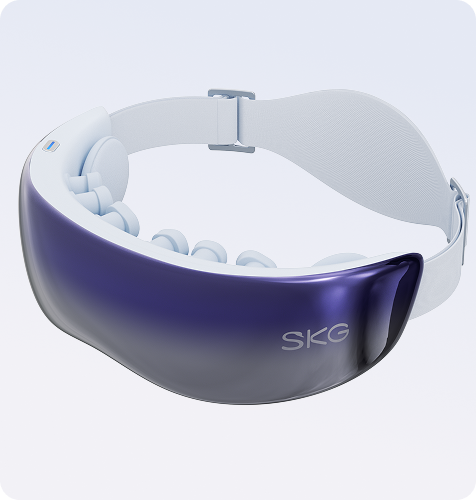 Masażer oczu SKG KS700. Widoczna fioletowo-lustrzana osłona, biały pasek i wewnętrzne podkładki masujące.